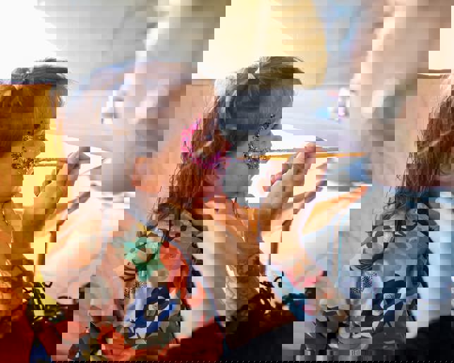 A young girl getting glitter painted on her face