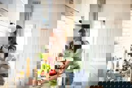 Woman preparing healthy meal laptop recipe