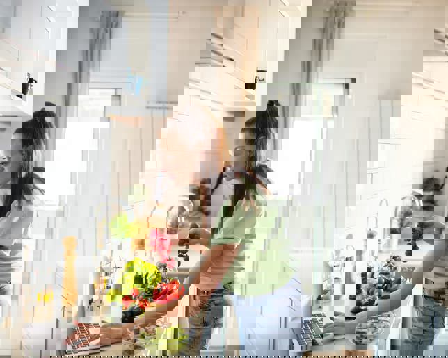 Woman preparing healthy meal laptop recipe