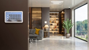 A home security system on the wall of an open plan living room