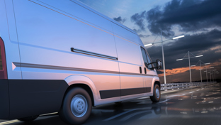 White delivery van driving along a wet highway at sunset with motion blur