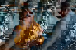 Businessman and businesswoman accountants sitting at a desk, discussing financial strategy using a laptop in the office.