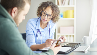 Female physician with stethoscope explains a prescription bottle to a patient during an office consultation