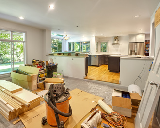 A room in the middle of renovation, with construction materials and tools scattered across the floor.