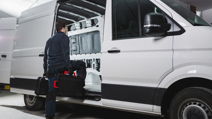 Worker entering into van with tools