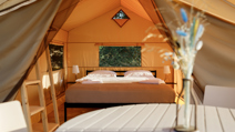 Cozy glamping tent interior during sunset