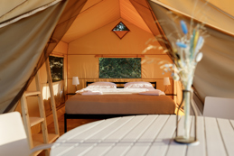 Cozy glamping tent interior during sunset