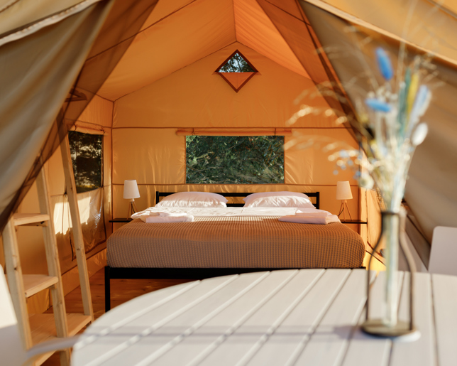 Cozy glamping tent interior during sunset