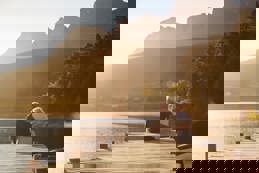 Senior couple sitting on lake jetty