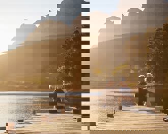 Senior couple sitting on lake jetty