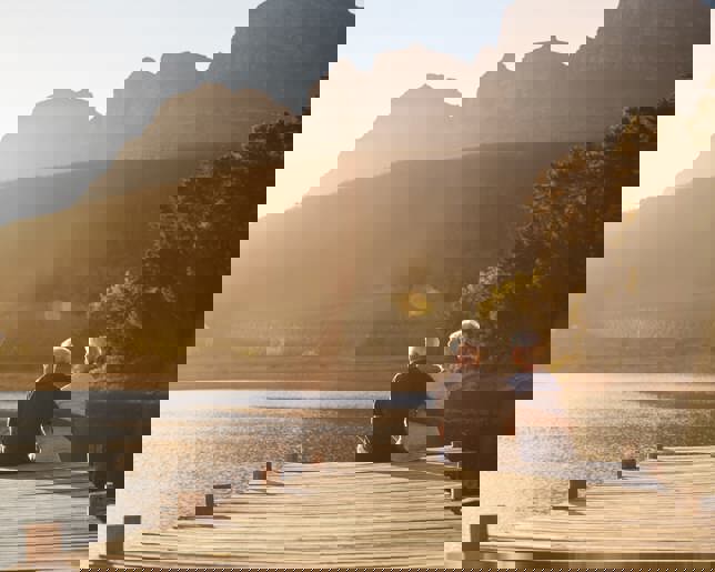 Senior couple sitting on lake jetty