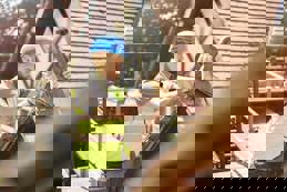 A builder is removing a finial on a roof of a period property.