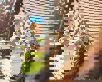 A builder is removing a finial on a roof of a period property.