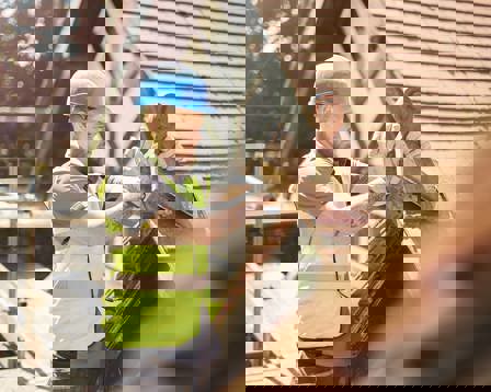 A builder is removing a finial on a roof of a period property.