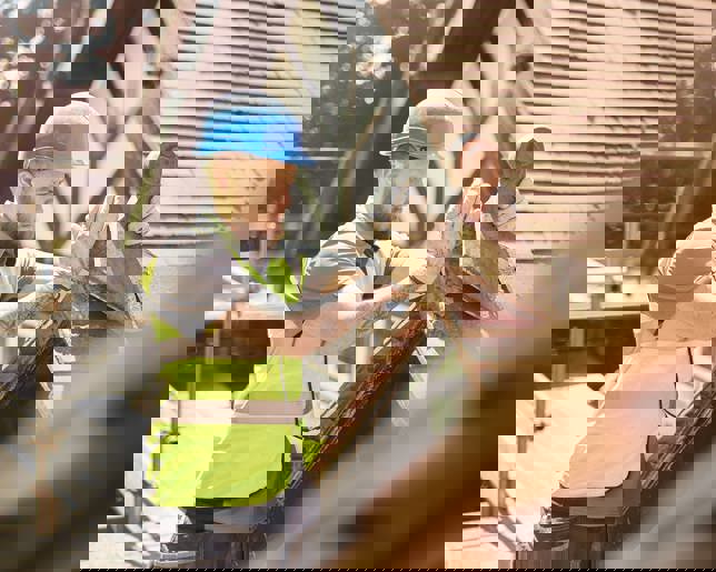 A builder is removing a finial on a roof of a period property.