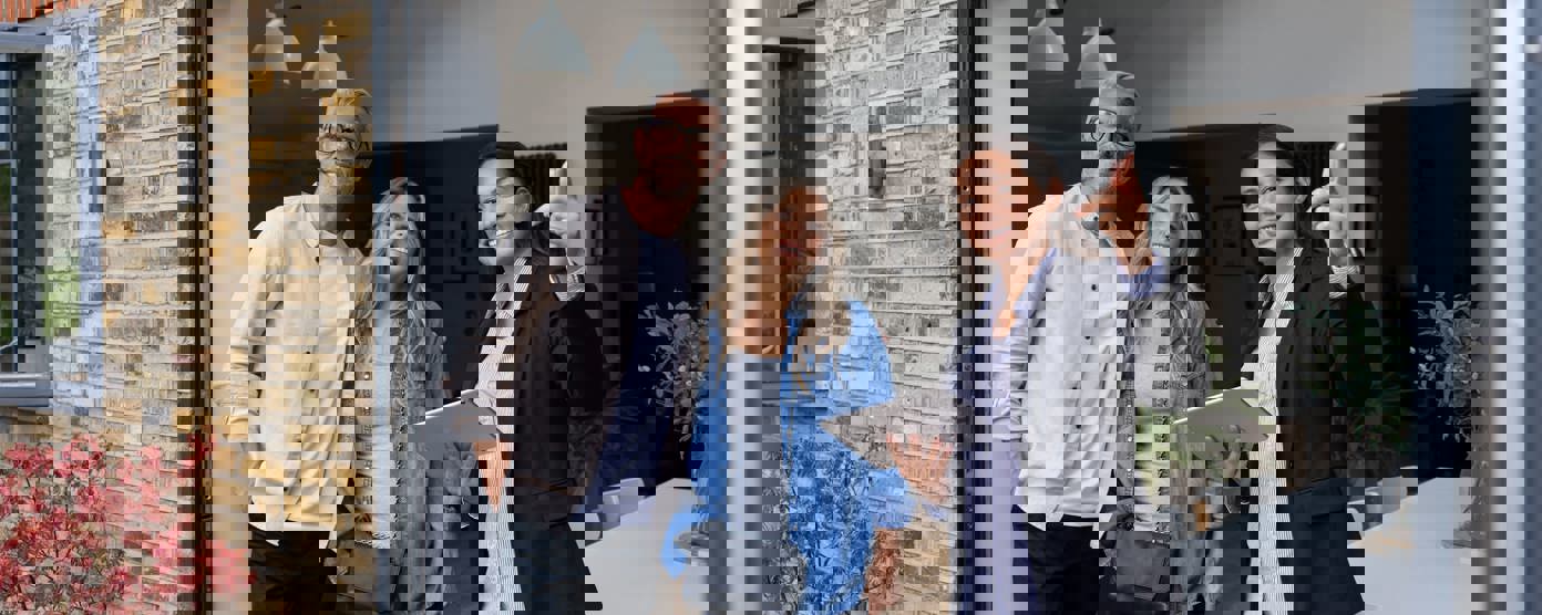 Real estate agent showing a house for sale to a couple.