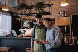 Coffee shop owner talking to employee