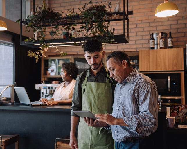 Coffee shop owner talking to employee