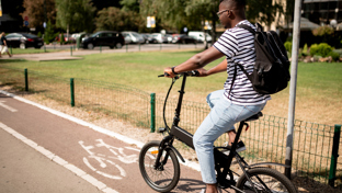 A young man is riding an electric bike on a dedicated bike path.