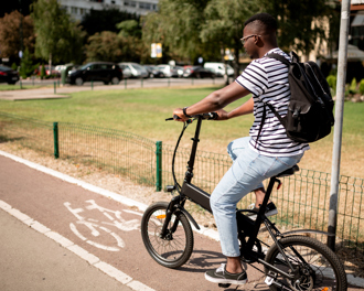 A young man is riding an electric bike on a dedicated bike path.