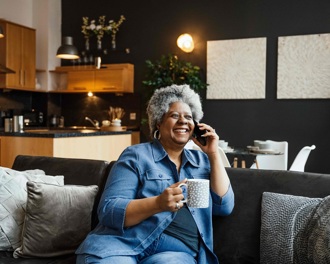 Lady smiling on the phone in her living room
